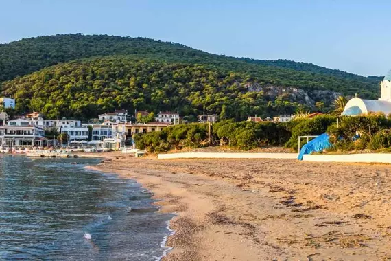 Panorama d'une plage sur l'île d'Agistri avec une église en arrière-plan